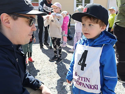 Isä Olli-Pekka Turtiainen auttoi Elieliä juoksunumeron pukemisessa.